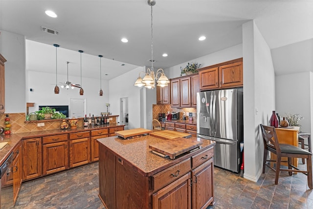 1114 Mount Ln, Rhome, TX 76078 - kitchen featuring stainless steel refrigerator with ice dispenser, decorative backsplash, dark stone finish floors, recessed lighting, and brown cabinets