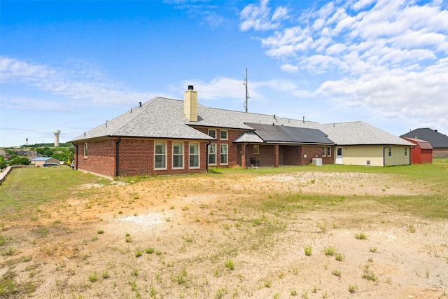 1114 Mount Ln, Rhome, TX 76078 - rear view of property with solar panels, brick siding, a chimney, and a shingled roof