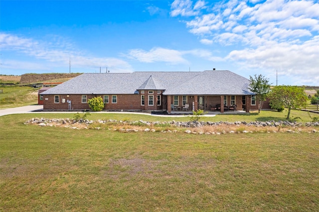 1114 Mount Ln, Rhome, TX 76078 - view of front facade featuring a front yard, brick siding, and a patio area