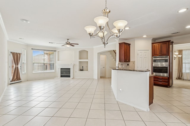 5723 Green Hollow Ln, The Colony, TX 75056 - kitchen with arched walkways, ceiling fan, light tile patterned floors, built in shelves, and crown molding
