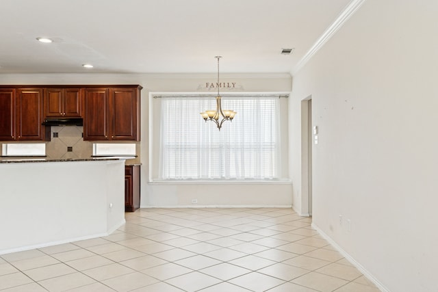 5723 Green Hollow Ln, The Colony, TX 75056 - kitchen featuring ornamental molding, a chandelier, under cabinet range hood, dark countertops, and backsplash