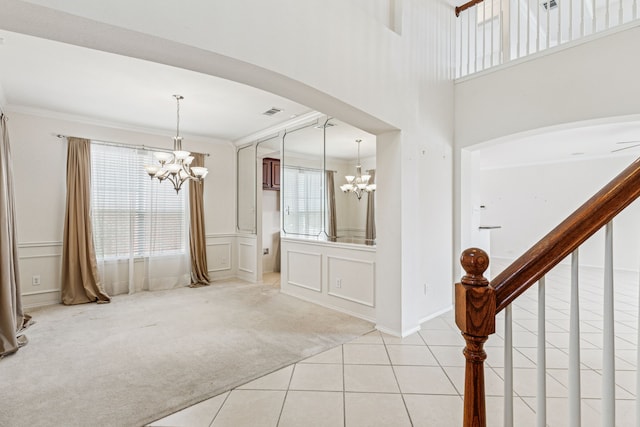 5723 Green Hollow Ln, The Colony, TX 75056 - foyer entrance with a chandelier, arched walkways, light carpet, ornamental molding, and light tile patterned floors