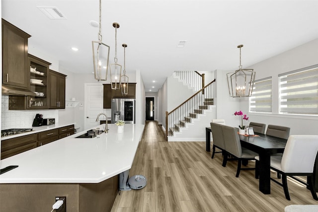 6329 Camey Place Way, The Colony, TX 75056 - kitchen with a sink, stainless steel appliances, dark brown cabinets, a chandelier, and open shelves