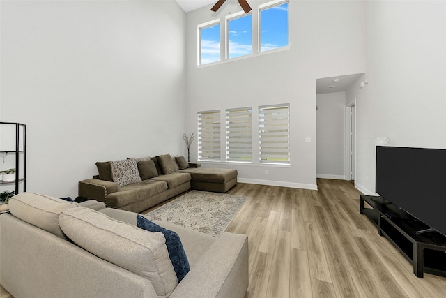 6329 Camey Place Way, The Colony, TX 75056 - living room with a high ceiling, ceiling fan, light wood-style floors, and baseboards