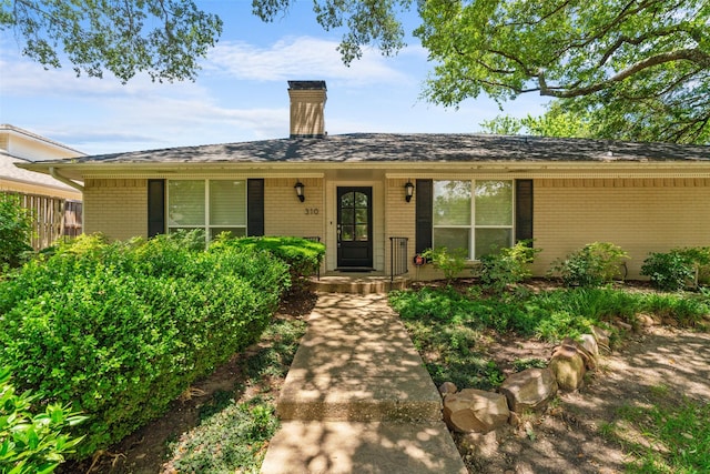 310 Northview Dr, Richardson, TX 75080 - view of front facade with brick siding and a chimney