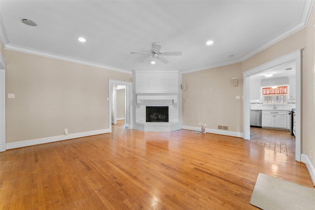 310 Northview Dr, Richardson, TX 75080 - unfurnished living room featuring ceiling fan, light wood-style floors, ornamental molding, a brick fireplace, and recessed lighting