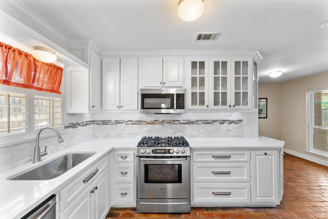 310 Northview Dr, Richardson, TX 75080 - kitchen with appliances with stainless steel finishes, a sink, brick floors, and tasteful backsplash