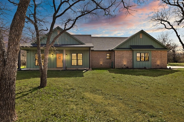 230 Silver Lakes Dr, Sunset, TX 76270 - back of property with board and batten siding, a shingled roof, brick siding, and a yard