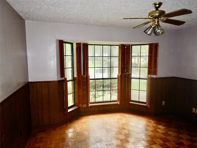 9217 Rhett Cir, Shreveport, LA 71118 - spare room featuring wooden walls, wainscoting, a textured ceiling, and ceiling fan