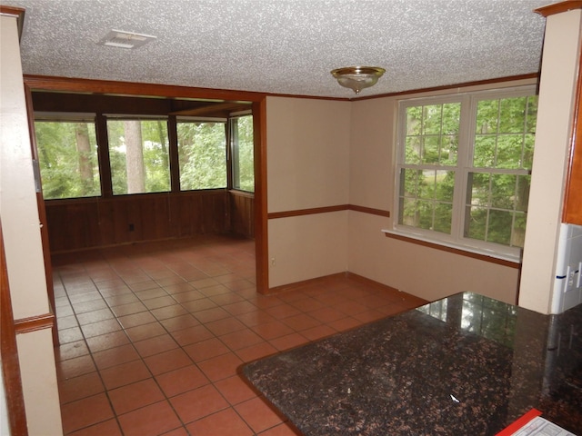 9217 Rhett Cir, Shreveport, LA 71118 - kitchen with tile patterned floors, a textured ceiling, dark stone countertops, and crown molding