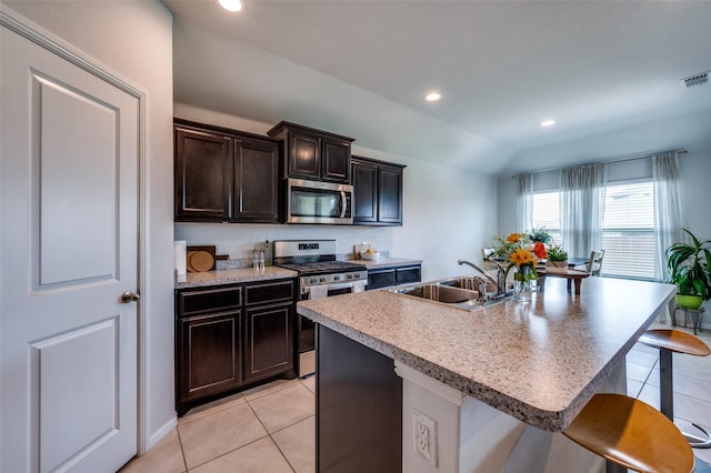 16421 Porterfield Ln, Justin, TX 76247 - kitchen with stainless steel appliances, a sink, a kitchen breakfast bar, light tile patterned flooring, and recessed lighting