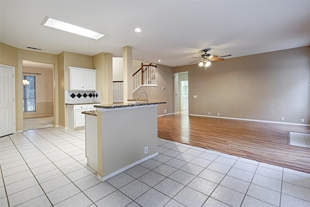 1503 Murphy Dr, Rockwall, TX 75087 - kitchen with light tile patterned floors, a ceiling fan, white cabinets, dark stone counters, and healthy amount of natural light