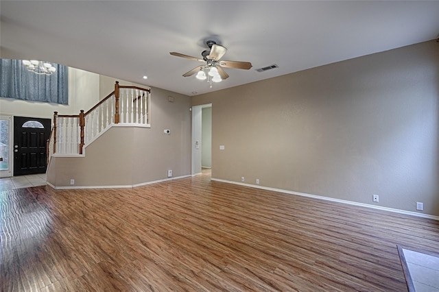 1503 Murphy Dr, Rockwall, TX 75087 - unfurnished living room with wood finished floors, a ceiling fan, baseboards, a chandelier, and stairs