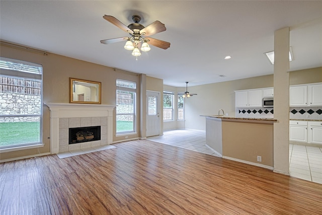 1503 Murphy Dr, Rockwall, TX 75087 - unfurnished living room with ceiling fan, light wood finished floors, a fireplace, recessed lighting, and baseboards