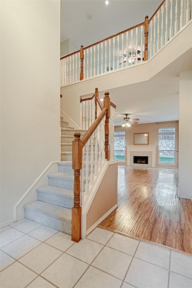 1503 Murphy Dr, Rockwall, TX 75087 - stairway with tile patterned flooring, a towering ceiling, a ceiling fan, and a tiled fireplace