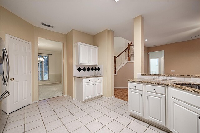 1503 Murphy Dr, Rockwall, TX 75087 - kitchen featuring light tile patterned floors, white cabinetry, light stone counters, backsplash, and baseboards