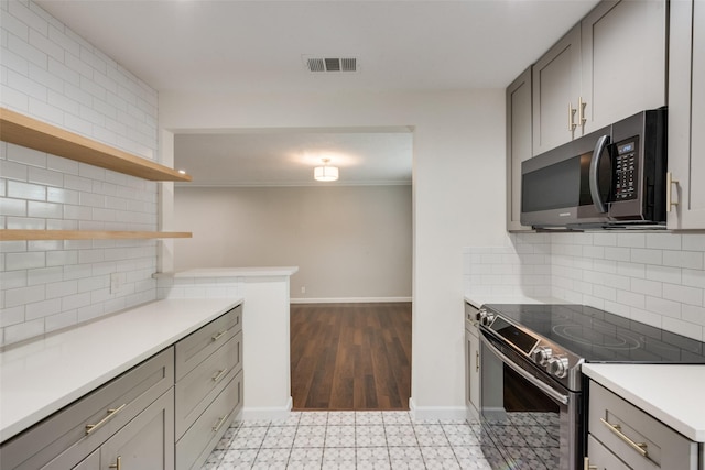 5010 Lahoma St, Dallas, TX 75235 - kitchen featuring stainless steel appliances, open shelves, gray cabinetry, light countertops, and tasteful backsplash