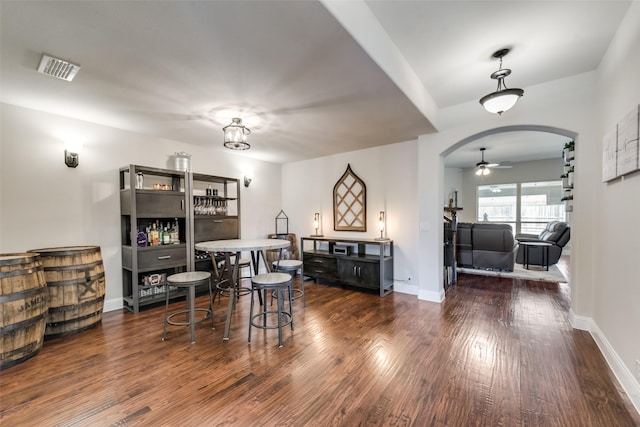 1003 Stanbridge Dr, Wylie, TX 75098 - dining area featuring wood finished floors, arched walkways, a ceiling fan, and baseboards