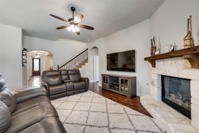 1003 Stanbridge Dr, Wylie, TX 75098 - living area featuring arched walkways, ceiling fan, wood finished floors, a stone fireplace, and stairway