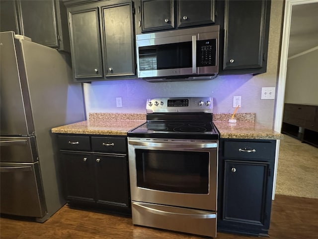14051 Joe B Fulgham Cir, Brownsboro, TX 75756 - kitchen with appliances with stainless steel finishes, dark cabinetry, dark wood-style flooring, and light stone counters