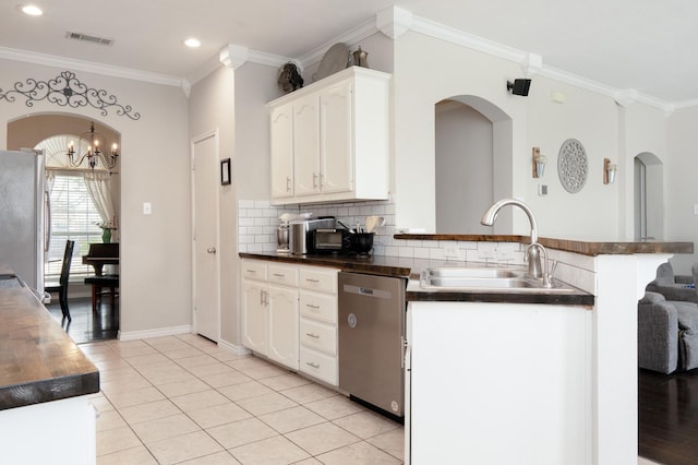 14221 Tijuana Trl, Fort Worth, TX 76052 - kitchen featuring stainless steel appliances, a sink, a peninsula, dark countertops, and arched walkways