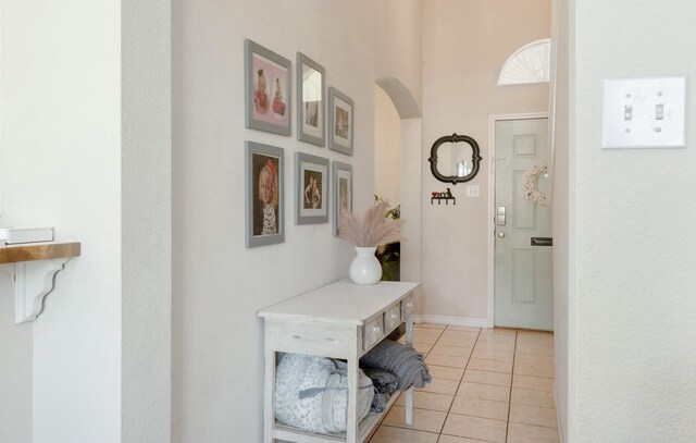 14221 Tijuana Trl, Fort Worth, TX 76052 - entrance foyer featuring arched walkways, light tile patterned floors, a high ceiling, and baseboards