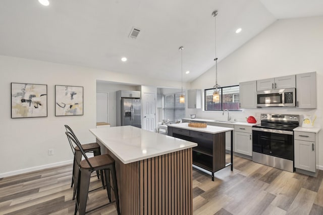405 Rosemary Ln, Euless, TX 76039 - kitchen featuring stainless steel appliances, a kitchen island, a sink, light countertops, and gray cabinetry