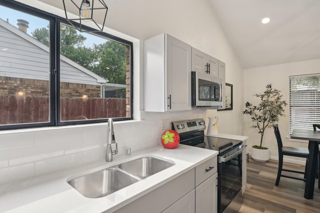405 Rosemary Ln, Euless, TX 76039 - kitchen with stainless steel appliances, a sink, backsplash, vaulted ceiling, and light countertops