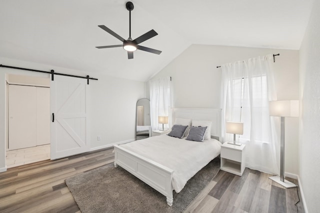 405 Rosemary Ln, Euless, TX 76039 - bedroom featuring vaulted ceiling, wood finished floors, a barn door, and ceiling fan