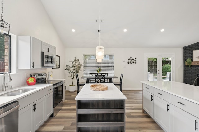 405 Rosemary Ln, Euless, TX 76039 - kitchen with stainless steel appliances, a sink, lofted ceiling, decorative light fixtures, and french doors