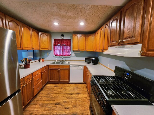2908 Wilkinson Ave, Fort Worth, TX 76103 - kitchen featuring appliances with stainless steel finishes, under cabinet range hood, a sink, a textured ceiling, and recessed lighting