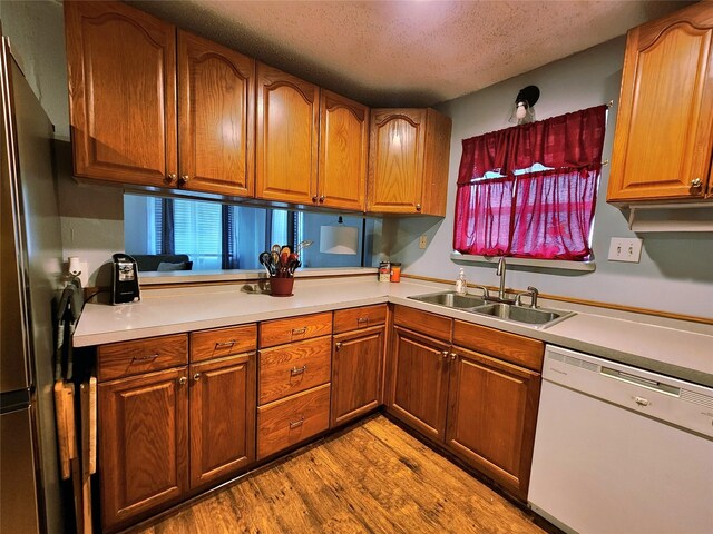 2908 Wilkinson Ave, Fort Worth, TX 76103 - kitchen with dishwasher, a sink, freestanding refrigerator, wood finished floors, and light countertops