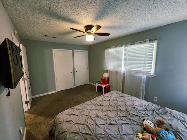 2908 Wilkinson Ave, Fort Worth, TX 76103 - carpeted bedroom with ceiling fan, a textured ceiling, baseboards, and multiple closets