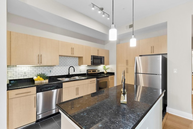 4605 Cedar Springs Rd Unit 339, Dallas, TX 75219 - kitchen with appliances with stainless steel finishes, light brown cabinetry, a sink, tasteful backsplash, and dark stone countertops
