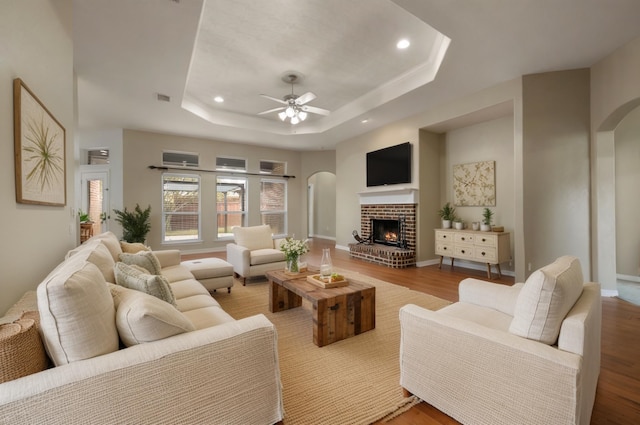 6345 Pinionpark Way, Fort Worth, TX 76179 - living area with a tray ceiling, arched walkways, ceiling fan, recessed lighting, and a fireplace