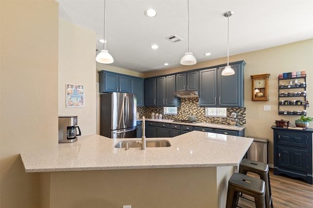 3625 Mackenzie Ln, Richardson, TX 75082 - kitchen featuring appliances with stainless steel finishes, a sink, a peninsula, decorative backsplash, and under cabinet range hood