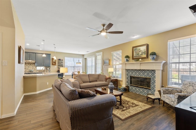 3625 Mackenzie Ln, Richardson, TX 75082 - living area with ceiling fan, dark wood finished floors, a tiled fireplace, baseboards, and recessed lighting