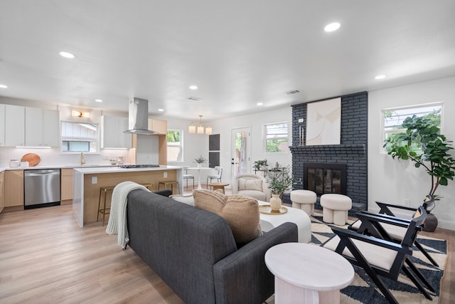 8317 Angier Way, Dallas, TX 75228 - living room with light wood-type flooring, recessed lighting, a brick fireplace, and a chandelier