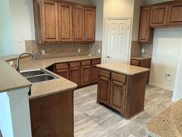 11711 Corsicana Dr, Frisco, TX 75035 - kitchen with a sink, light wood finished floors, a peninsula, and light stone counters