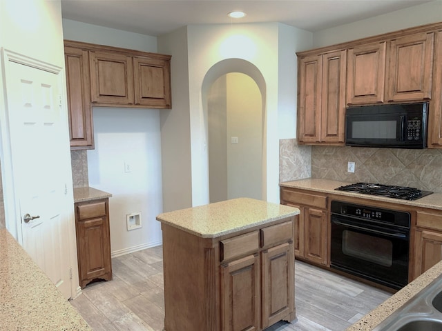 11711 Corsicana Dr, Frisco, TX 75035 - kitchen with black appliances, light wood-style flooring, recessed lighting, tasteful backsplash, and light stone countertops