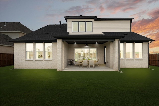 2016 Morris St, Rockwall, TX 75087 - back of property at dusk featuring a ceiling fan, a patio, and a shingled roof