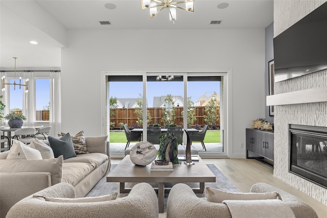 2016 Morris St, Rockwall, TX 75087 - living room featuring a chandelier, light wood finished floors, a large fireplace, and recessed lighting