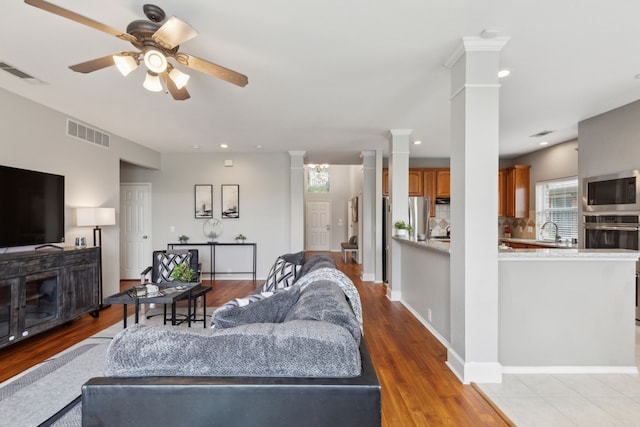 11487 Balcones Dr, Frisco, TX 75033 - living area with decorative columns, a ceiling fan, light wood-style floors, and recessed lighting