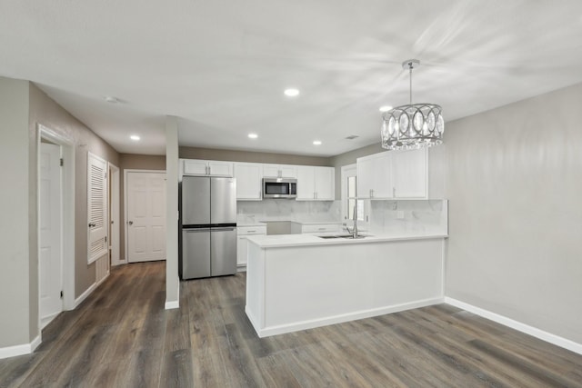 6405 Waynewood Ct, Fort Worth, TX 76135 - kitchen featuring appliances with stainless steel finishes, a sink, baseboards, dark wood-style floors, and white cabinetry