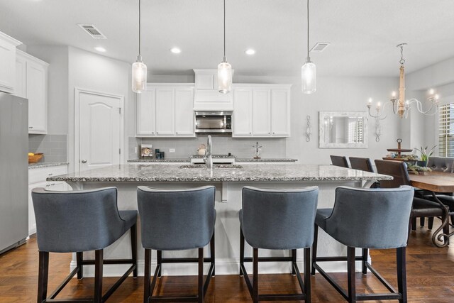 1761 Stillwater Dr, Burleson, TX 76028 - kitchen featuring appliances with stainless steel finishes, backsplash, a center island with sink, recessed lighting, and white cabinets