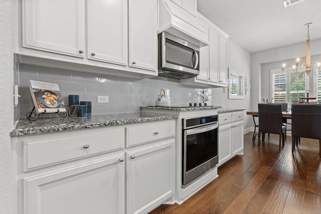 1761 Stillwater Dr, Burleson, TX 76028 - kitchen featuring stainless steel appliances, a chandelier, tasteful backsplash, and white cabinets