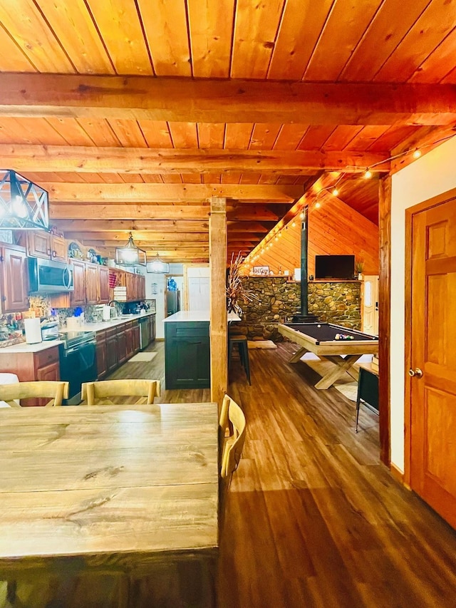 307 S King Lake Rd, Scroggins, TX 75480 - dining space featuring wood ceiling with exposed beams, decorative columns, wooden walls, wood finished floors, and a wood stove