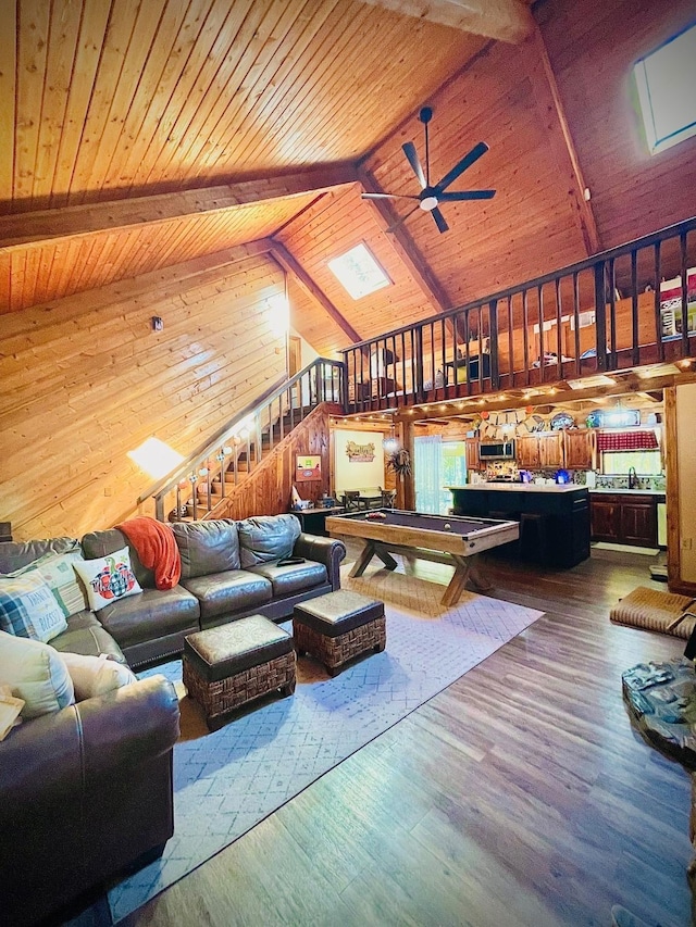 307 S King Lake Rd, Scroggins, TX 75480 - living area with wooden ceiling with exposed beams, a ceiling fan, wood walls, dark wood-style floors, and stairway