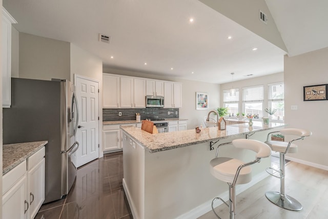 5309 Chatsworth Ln, Fort Worth, TX 76244 - kitchen with stainless steel appliances, a spacious island, white cabinetry, light stone countertops, and tasteful backsplash