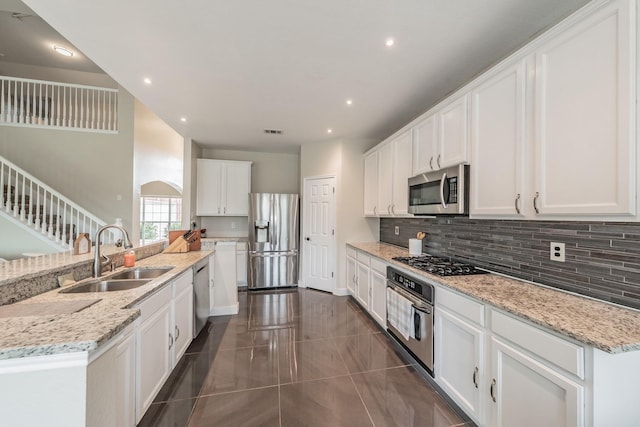 5309 Chatsworth Ln, Fort Worth, TX 76244 - kitchen with appliances with stainless steel finishes, a sink, decorative backsplash, white cabinetry, and light stone counters